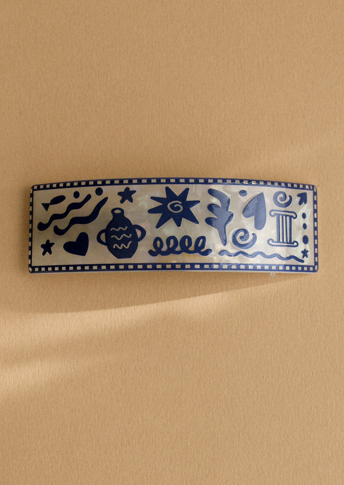 A pearl white barrette with grecian inspired vacation print.