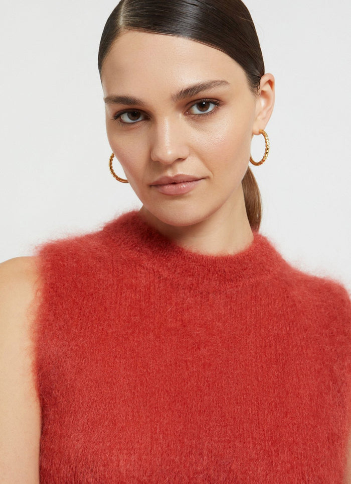 A super fuzzy sweater vest in vibrant raspberry color.