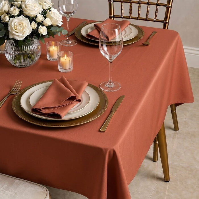 Terracotta rectangle tablecloth on a dining table with elegant place settings.