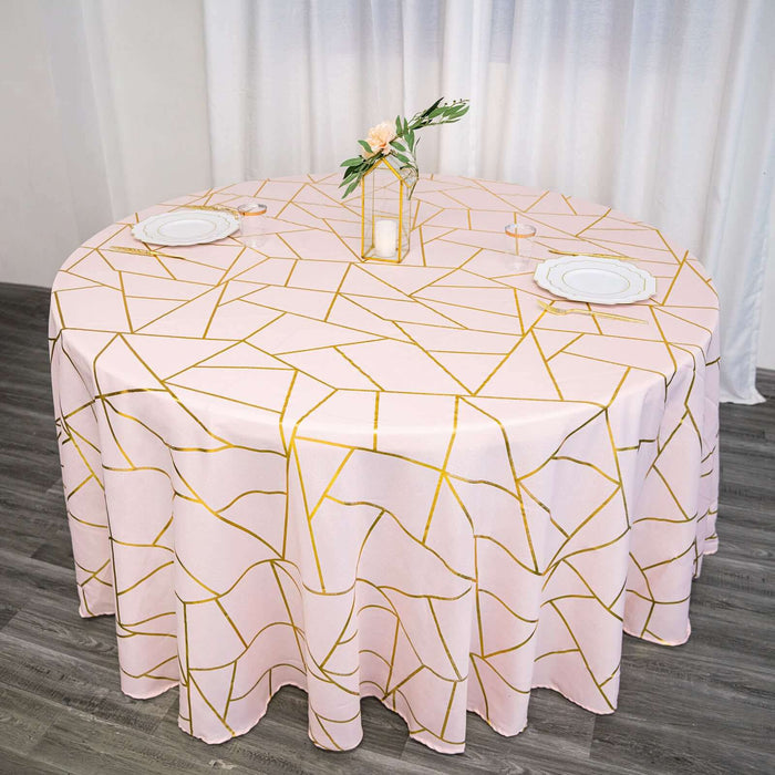 Round pink tablecloth with gold geometric design on a dining table.