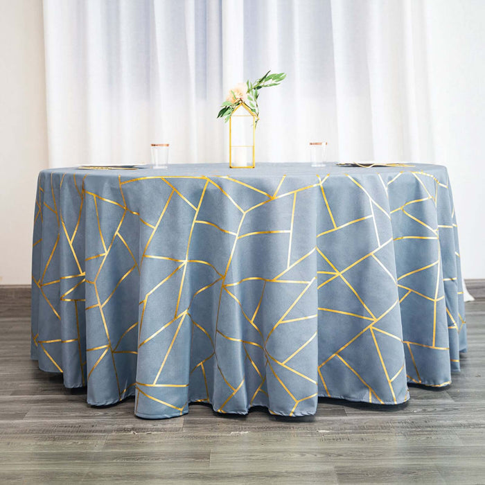 Blue tablecloth with gold geometric pattern on a round table in a staged setting.
