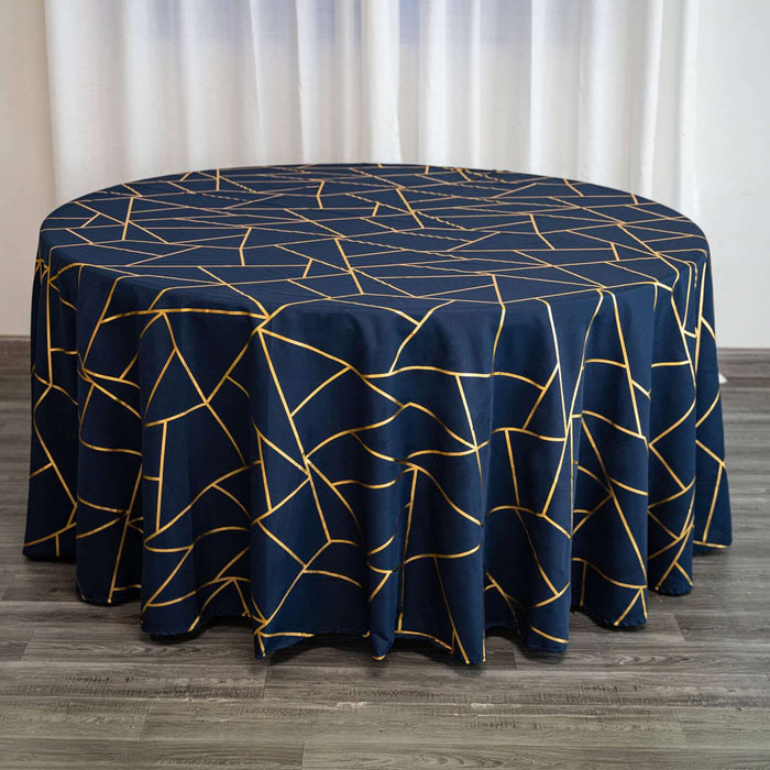 Round navy tablecloth with gold geometric pattern on a wooden surface.