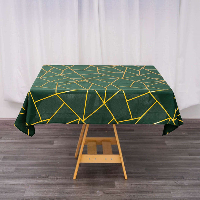 Green tablecloth with geometric yellow pattern on wooden table.