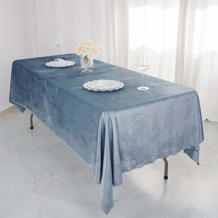 Elegant blue tablecloth draped over a table with plates and glasses.