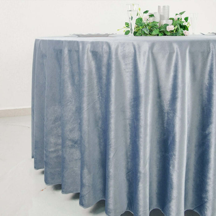 Elegant blue tablecloth draping a round table with floral centerpiece.