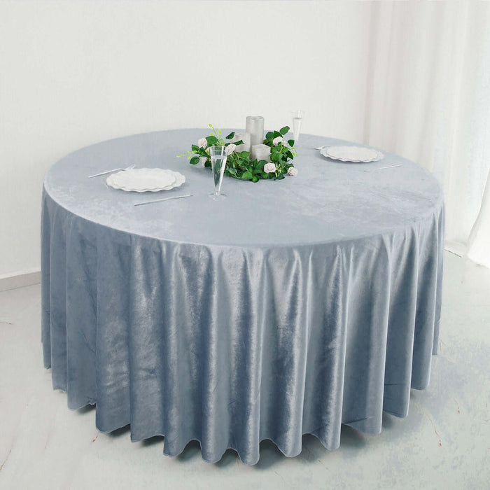 Round gray velvet tablecloth on a table, elegantly styled with plates and decor.