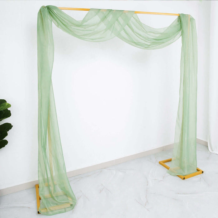Green sheer drapery hanging from a wooden frame in a studio setting