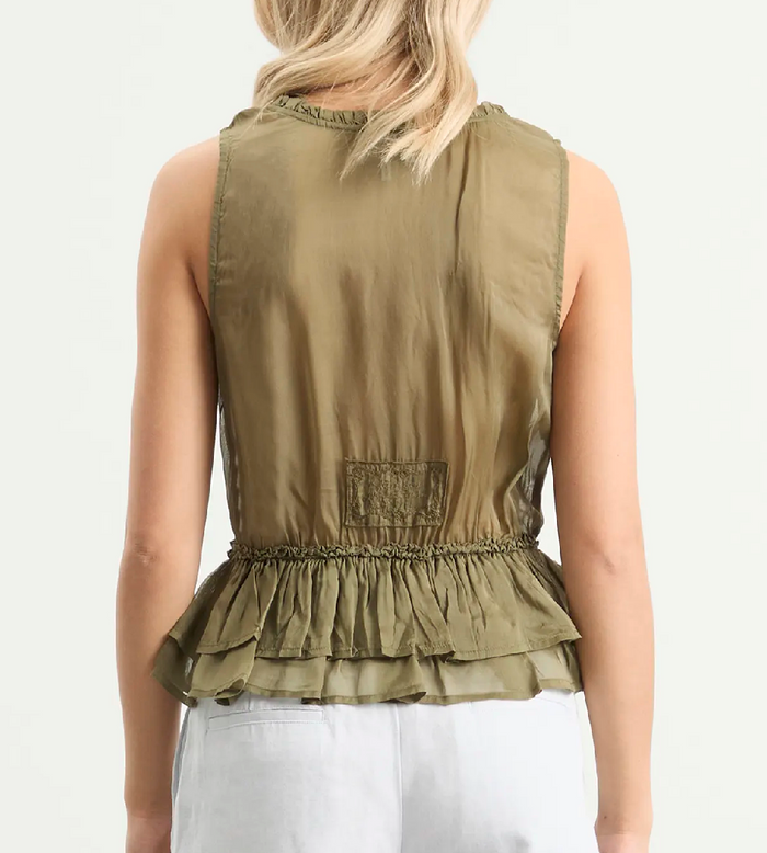 Woman wearing an olive sleeveless top with a ruffled bottom on a white background