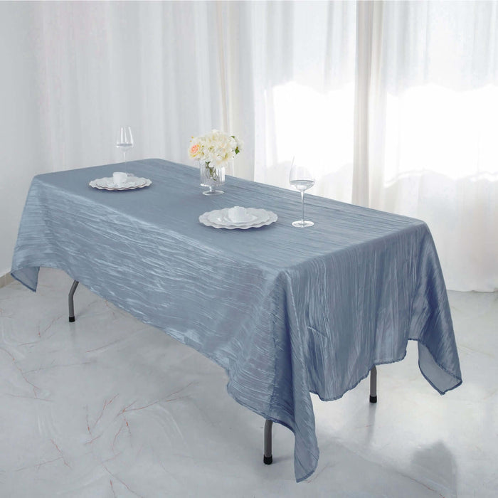 Elegant blue tablecloth draped over a table with floral centerpiece and dinnerware.