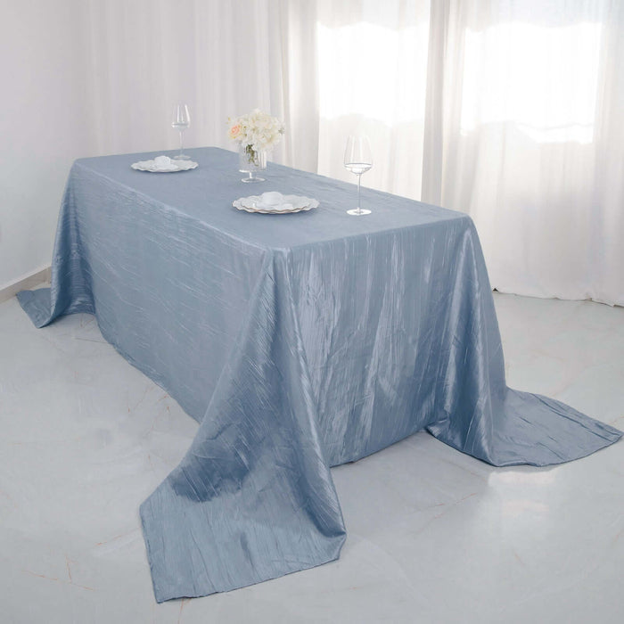 Elegant blue tablecloth draped over a table with glassware and floral centerpiece.