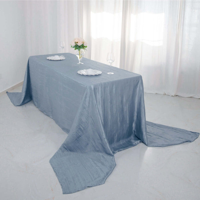 Elegant blue tablecloth draped over a table set with plates and glasses.