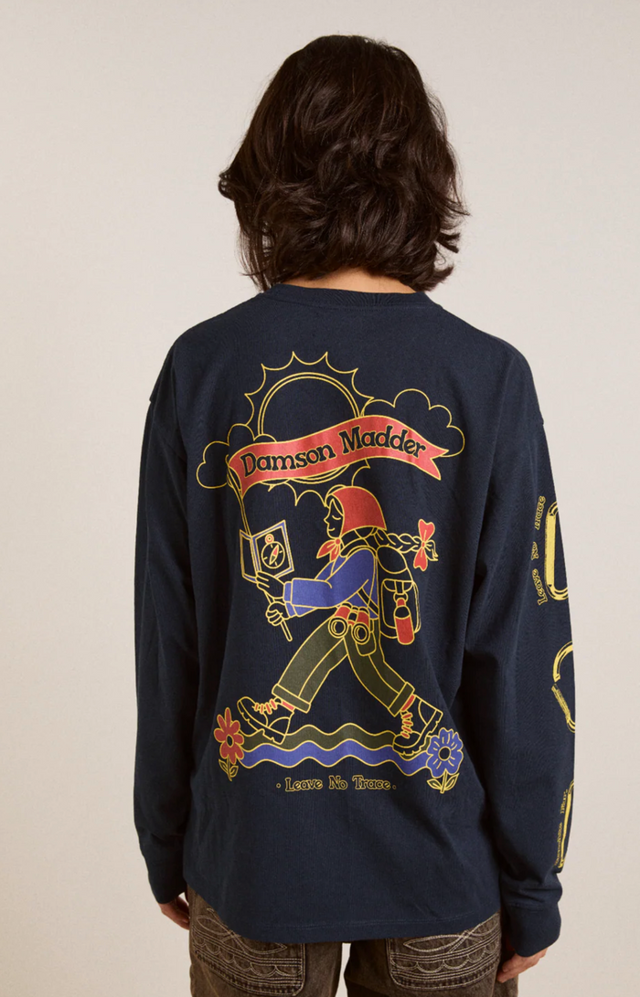 Person wearing a navy blue long-sleeve shirt with colorful graphics and text on the back.