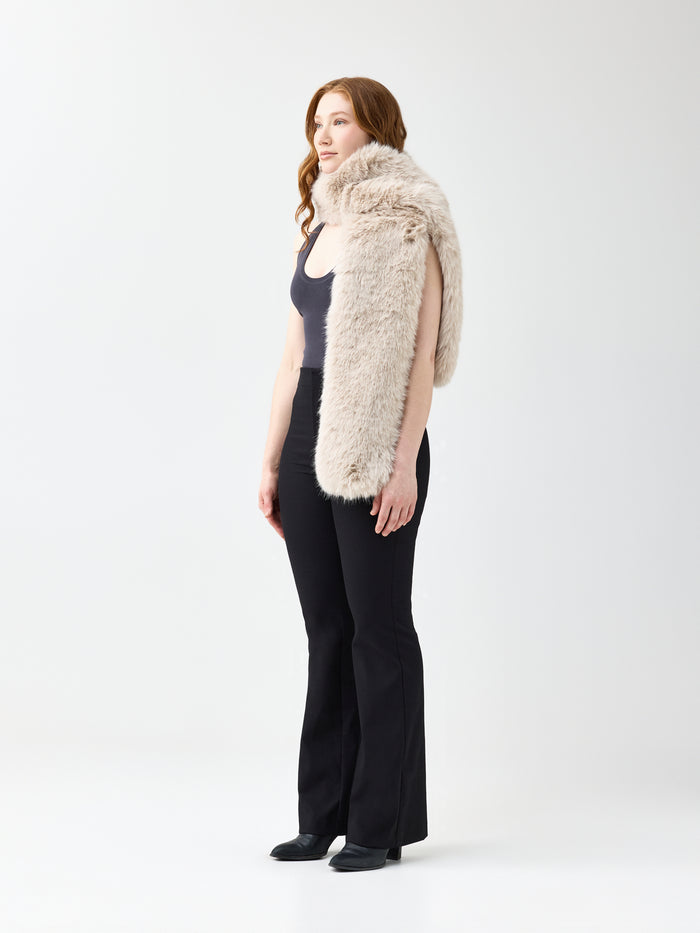 Woman wearing a beige faux fur scarf on a white background
