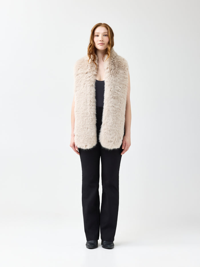 Woman wearing a beige faux fur scarf on a white background
