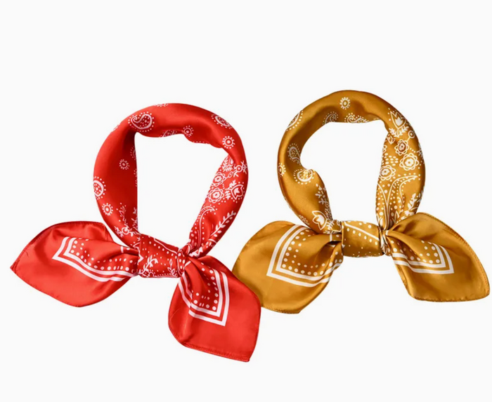 Two bandanas, one red and one gold, with white patterns on a white background